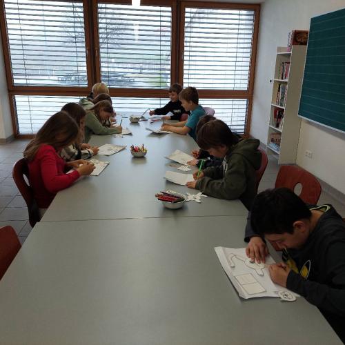 Kinder basteln eine Katze aus Papier