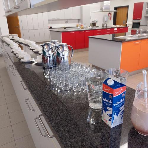 Teller, Tassen, Kannen mit Kakao und Wassergläser am Buffet der Lehrküche