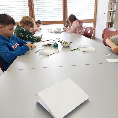 Kinder basteln eine Katze aus Papier