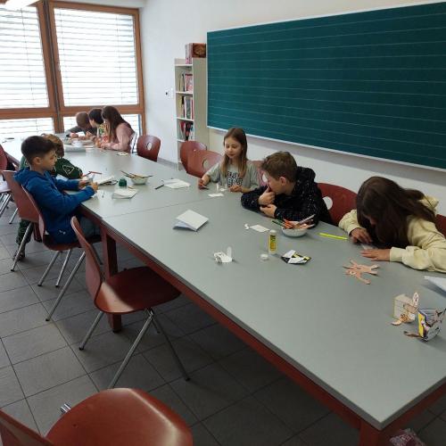 Kinder basteln eine Katze aus Papier