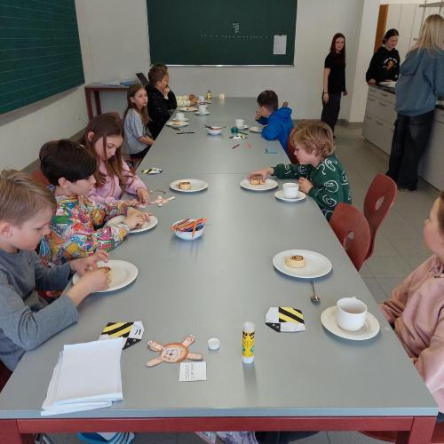 Kinder essen Zimtschnecken und Trinken Kakao
