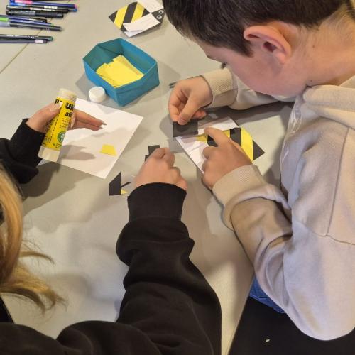 Kinder basteln eine Biene aus Papier