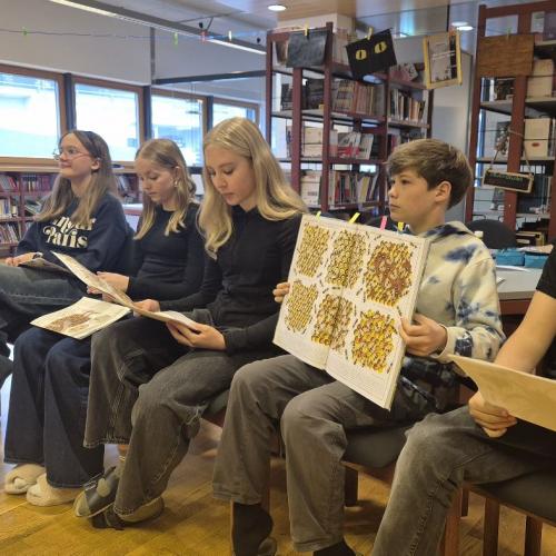 Mittelschülerinnen und Mittelschüler lesen aus einem Sachbuch vor