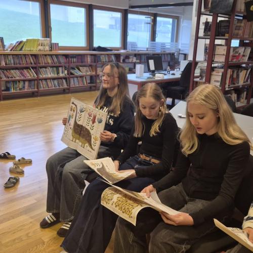 Mittelschülerinnen und Mittelschüler lesen aus einem Sachbuch vor