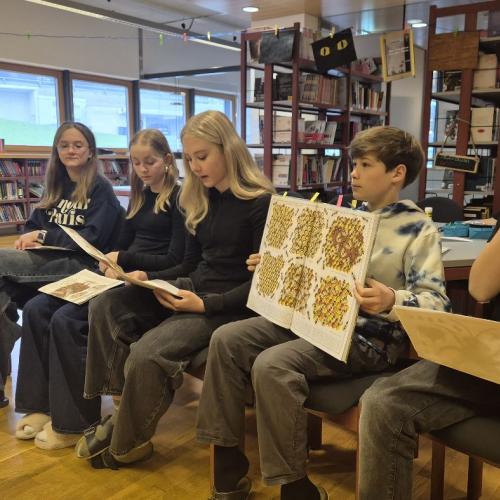 Mittelschüler und Mittelschülerinnen lesen aus einem Sachbuch vor