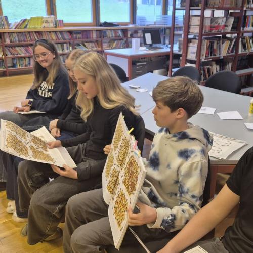 Mittelschülerinnen und Mittelschüler lesen aus einem Sachbuch vor