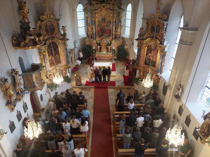 Blick von oben in einen Kirchenraum, indem eine Heilige Messe gefeiert wird.