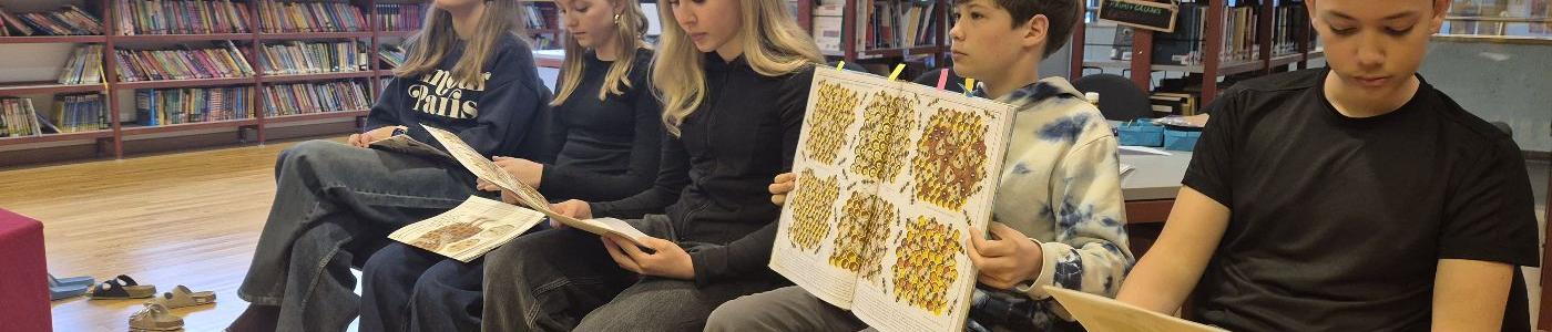 Mittelschülerinnen und Mittelschüler lesen aus einem Sachbuch vor