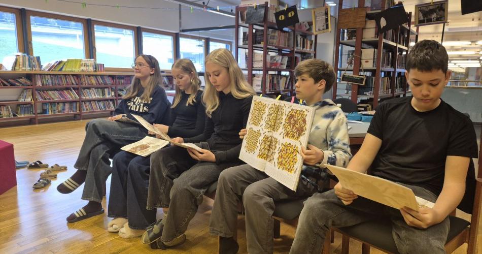 Mittelschülerinnen und Mittelschüler lesen aus einem Sachbuch vor